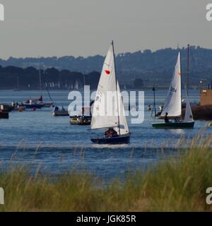 Yacht retroilluminato vele dietro la duna di sabbia Marram erba. Exmouth da Dawlish Warren, Devon, Regno Unito. Luglio, 2017. Foto Stock