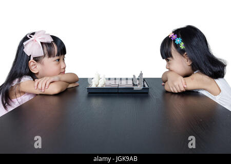 Cinese asiatici piccole sorelle giocando a scacchi insieme a casa. Foto Stock