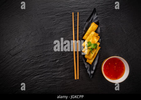 Asian soup Pho bo con involtini primavera, vista dall'alto, servita sulla pietra nera. Foto Stock