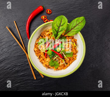 Asian pollo e curry di gamberi con riso, vista dall'alto, servita sulla pietra nera. Foto Stock