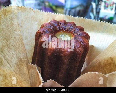 Un canelé è una piccola pasticceria francese aromatizzata con il rum e vaniglia con un panno morbido e tenero centro di crema pasticcera e uno scuro, spessa crosta caramellate. Esso prende th Foto Stock