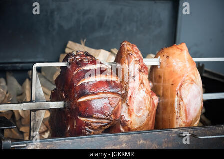 Arrosto di maiale knuckles allo spiedo per una grande azienda Foto Stock