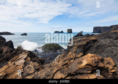 Mare di basalto pile nell'oceano al largo della costa meridionale dell'Islanda Foto Stock