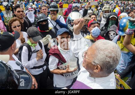 Un sacerdote benedice i manifestanti sulla superstrada. I dimostranti dell opposizione assemblato su Francisco Fajardo autostrada, vicino a Francisco de Miranda Air Force Foto Stock