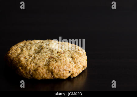 In casa singola di farina di avena cookie, dessert sano, su sfondo scuro. Copia dello spazio. Messa a fuoco selettiva Foto Stock