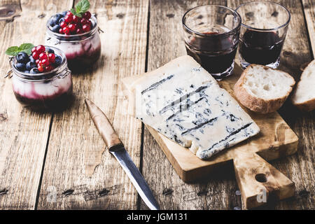 Formaggio Gorgonzola rustico sul tagliere di legno e tradizionali fatti in casa dolce italiano panna cotta, traditioanal cucina italiana Foto Stock