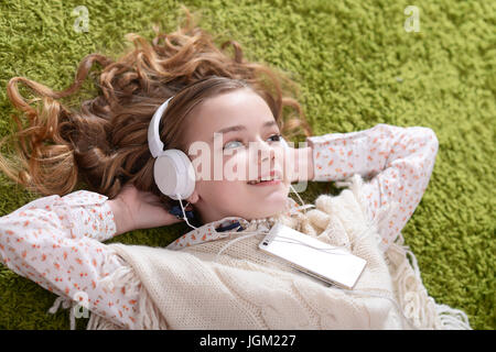 Carino bambina ascoltando musica Foto Stock