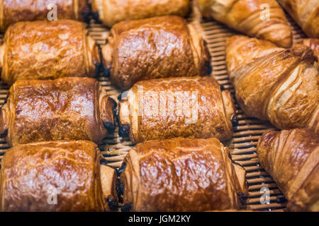 Macro closeup di croissant al cioccolato sul display in panetteria con pasticcini semplici Foto Stock