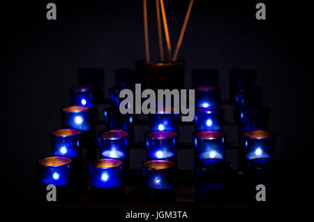 Candele lunghe e sottili che bruciano in una chiesa. Vista ravvicinata Foto  stock - Alamy