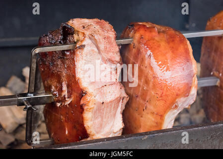 Arrosto di maiale knuckles allo spiedo per una grande azienda Foto Stock