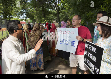 Vari membri di Kensington quartiere di Brooklyn venuto fuori per sostenere i musulmani provenienti da varie nazioni, gruppi di immigranti che si ritrovano sul Eid in Prospect Park di Brooklyn, NY a pregare insieme. Eid al-Fitr "festa della rottura del digiuno") è un importante festa religiosa celebrata dai musulmani di tutto il mondo che segna la fine del Ramadan, islamica del sacro mese del digiuno (sawm). Foto Stock