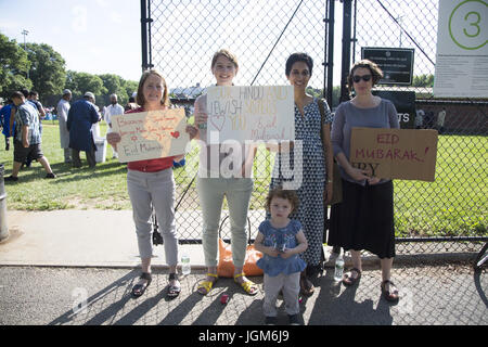 Vari membri di Kensington quartiere di Brooklyn venuto fuori per sostenere i musulmani provenienti da varie nazioni, gruppi di immigranti che si ritrovano sul Eid in Prospect Park di Brooklyn, NY a pregare insieme. Eid al-Fitr "festa della rottura del digiuno") è un importante festa religiosa celebrata dai musulmani di tutto il mondo che segna la fine del Ramadan, islamica del sacro mese del digiuno (sawm). Foto Stock