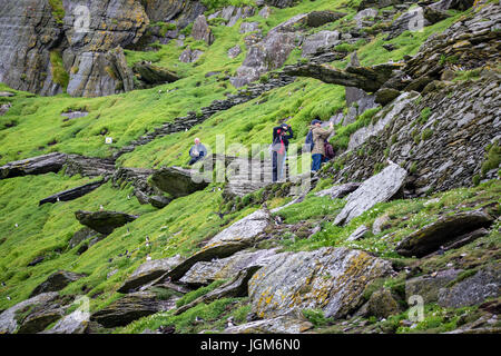 I turisti la scalata di gradini di pietra su Skellig Michael, nella contea di Kerry Irlanda Foto Stock
