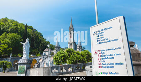Lourdes, Francia, giugno 22, 2017 - Segno della direzione di fronte alla basilica del santuario di Lourdes, Francia Foto Stock