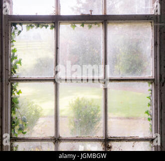 Un vecchio e sporco e finestra con una sensazione di abbandono e di malinconia Foto Stock