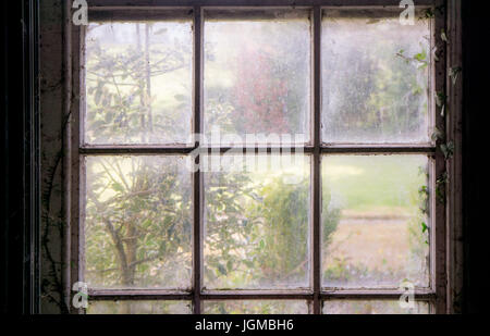 Un vecchio e sporco e finestra con una sensazione di abbandono e di malinconia Foto Stock