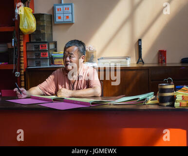 Kuala Lumpur, Malesia - giu 6, 2015. Un uomo seduto al tempio Cinese a Chinatown, Kuala Lumpur, Malesia. Foto Stock