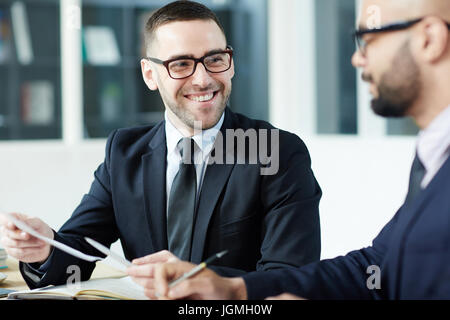 Felice datore di lavoro guardando il business partner durante la conversazione Foto Stock
