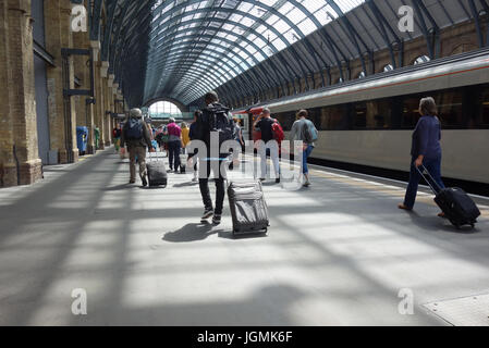 I passeggeri che arrivano alla stazione di King Cross, London, Regno Unito Foto Stock