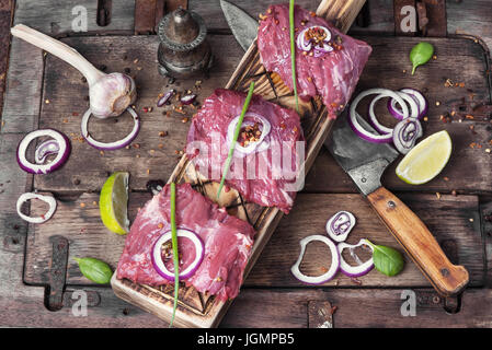 Raw carne di vitello.raw carni bovine bistecca su legno tavolo rustico Foto Stock