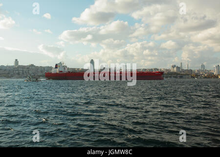 Industrial nave passando lo stretto del Bosforo, Istanbul, Turchia; panorama cittadino con ponte in background Foto Stock