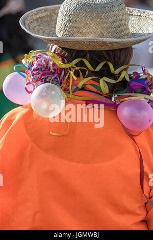 Uomo che indossa un cappello di paglia maglietta arancione e palloncini Foto Stock