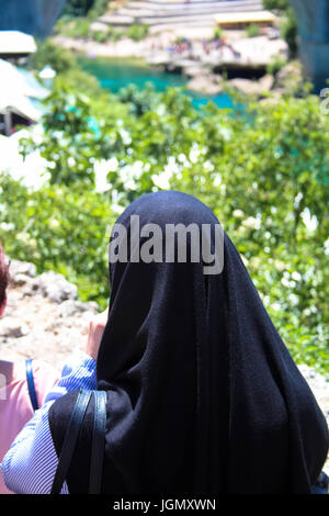 Signora musulmana che guarda al fiume Neretva, Bosnia Foto Stock