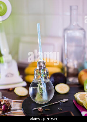 Il design piccolo vaso con paglia riempito con acqua di infuso di limone, la paglia. Fresche, estate umore. Foto Stock