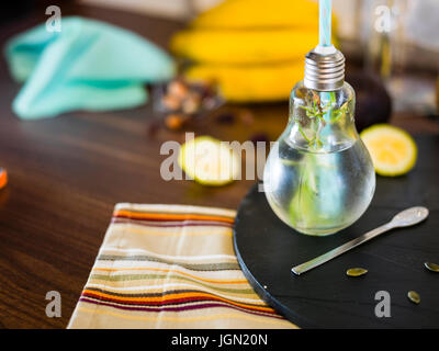 Il design piccolo vaso con paglia riempito con acqua di infuso di limone, la paglia. Fresche, estate umore. Foto Stock