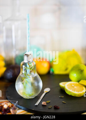 Il design piccolo vaso con paglia riempito con acqua di infuso di limone, la paglia. Fresche, estate umore. Foto Stock