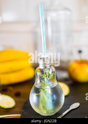 Il design piccolo vaso con paglia riempito con acqua di infuso di limone, la paglia. Fresche, estate umore. Foto Stock