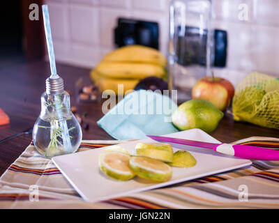 Il design piccolo vaso con paglia riempito con acqua di infuso di limone, la paglia. Fresche, estate umore. Foto Stock