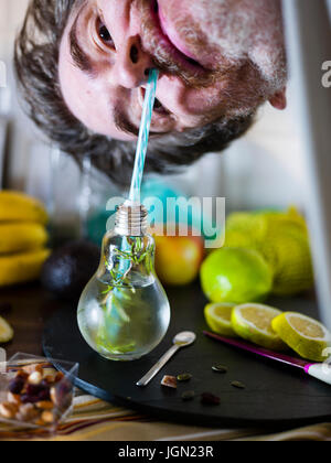 Il design piccolo vaso con paglia riempito con acqua di infuso di limone, la paglia. Fresche, estate umore. Foto Stock