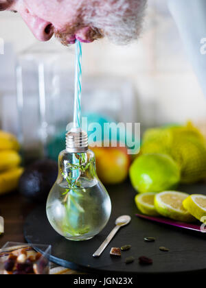 Il design piccolo vaso con paglia riempito con acqua di infuso di limone, la paglia. Fresche, estate umore. Foto Stock