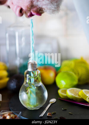 Il design piccolo vaso con paglia riempito con acqua di infuso di limone, la paglia. Fresche, estate umore. Foto Stock