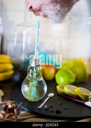 Il design piccolo vaso con paglia riempito con acqua di infuso di limone, la paglia. Fresche, estate umore. Foto Stock