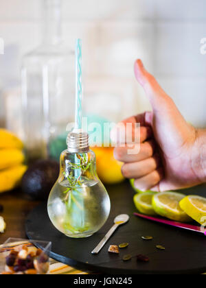 Il design piccolo vaso con paglia riempito con acqua di infuso di limone, la paglia. Fresche, estate umore. Foto Stock