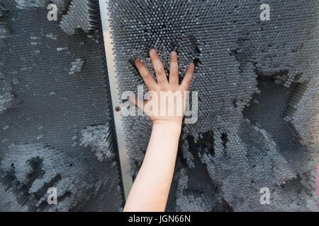 Persone, infanzia, il gesto e le parti del corpo concetto - close up bambino mano sollevata e giocare con il giocattolo moderno. Foto Stock