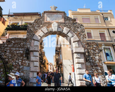 TAORMINA, Italia - 29 giugno 2017: i turisti a piedi attraverso il gateway precedente Porta Messina nella città di Taormina. Taormina è una località di villeggiatura sul Mar Ionio in Sicilia Foto Stock