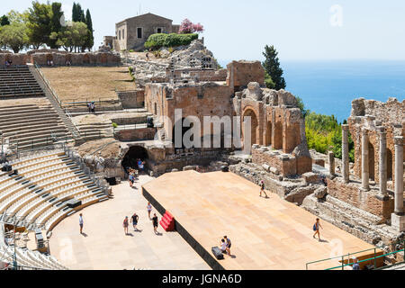 TAORMINA, Italia - 29 giugno 2017: i visitatori nel Teatro Antico di Taormina, antico teatro greco (Teatro Greco) nella città di Taormina in giorno d'estate. Il amphi Foto Stock