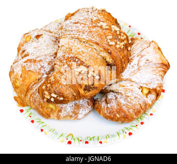 Tre italiani freschi croissants riempito da vaniglia e cioccolato sulla piastra isolata su sfondo bianco Foto Stock