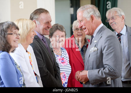 Il Principe di Galles (destra) incontra i membri della comunità a comunità Myddfai Hall di Myddfai, Llandovery, prima inaugurazione di una nuova vetrata, sul tema delle leggende gallese, creato da persone locali durante l. Foto Stock