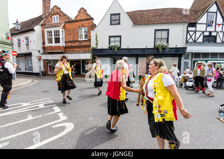 Inghilterra, sandwich e folk festival ale. Kent Korkers & Scratchin porta del lato di Morris ballare tenendo pali in legno, per le strade della città medievale. Foto Stock