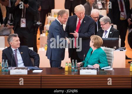 Stati Uniti Presidente Donald Trump saluta Unione europea presidente Donald Tusk come il Cancelliere tedesco Angela Merkel si affaccia sulla prima dell' inizio della terza sessione plenaria nella giornata conclusiva del vertice G20 meeting al commercio di Amburgo Centro Congressi Luglio 8, 2017 ad Amburgo, in Germania. (Bundesregierung/Bergmann via Planetpix) Foto Stock