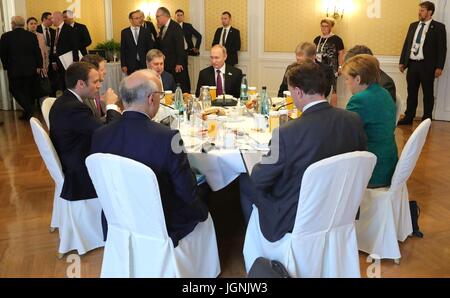 Il cancelliere tedesco Angela Merkel, il presidente russo Vladimir Putin, centro e il presidente francese Emmanuel Macron durante un lavoro trilaterale colazione a margine del vertice del G20 incontro Luglio 8, 2017 ad Amburgo, in Germania. Foto Stock