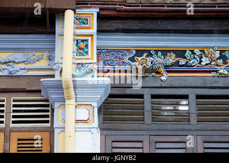 Finestre a lucernario e ornato di decorazioni su la rinnovata facciata di un tradizionale-Peranakan stile (Stretto Cinese) bottega, George Town, Pulau Pina Foto Stock