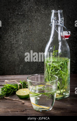 Estate ristoro bevande dietetiche. Infusa detox acque in diversi tipi di bicchieri con limone e il dragoncello. Rustici di legno vecchio tavolo spazio di copia Foto Stock