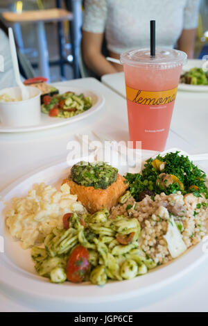Piastra di vari tipi di insalate e salmone con un cocomero limonata da un la-basato ristorante della catena Foto Stock