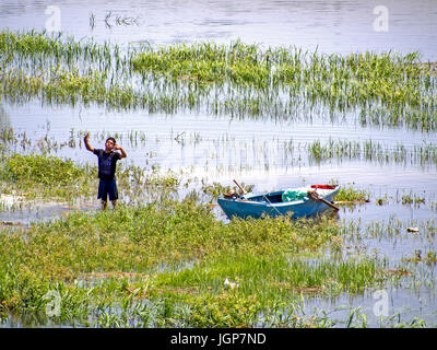 Un uomo si erge nell'acqua del fiume Nilo, Luxor, Egitto Foto Stock