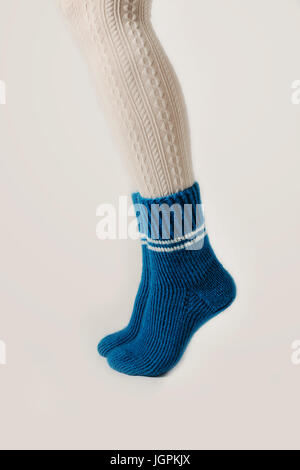 Gambe femmina in calze bianche e blu Calze a maglia. Foto Stock